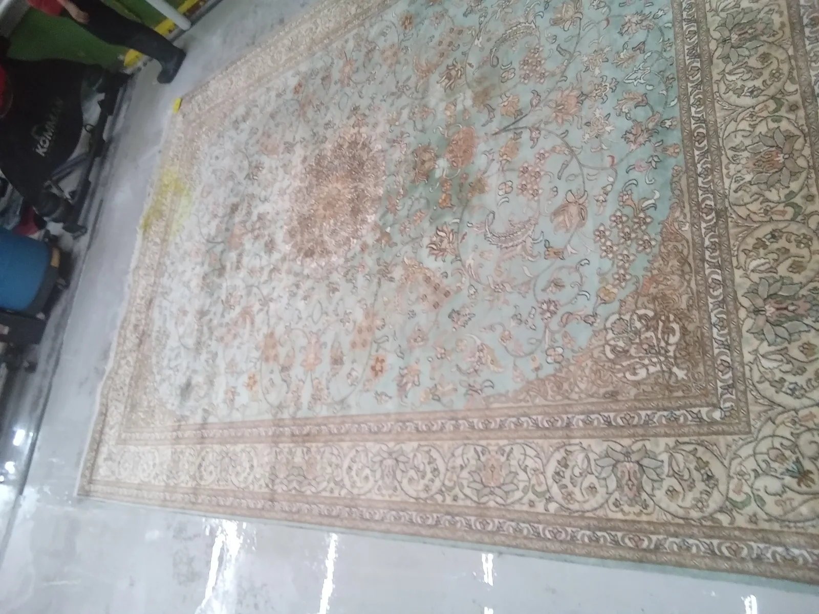 A pale, finely woven rug spread out at the plant, in for cleaning from Boynton Beach